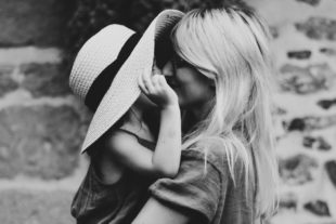 Mother holding child wearing sunhat